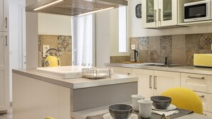 Een moderne keuken met een centraal eiland, een magnetron en een broodrooster.