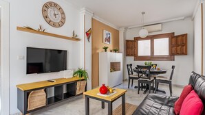 A modern living room with a TV, wooden console, and a leather sofa. - Luxury Suite Ancha de la Virgen (Granada)