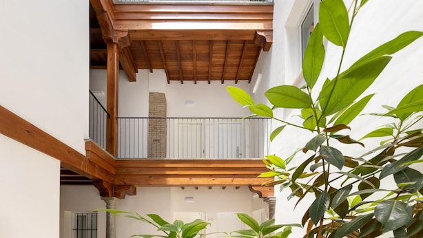Ein mehrstufiger Holzbalkon mit weißen Geländern und einer Steinsäule.