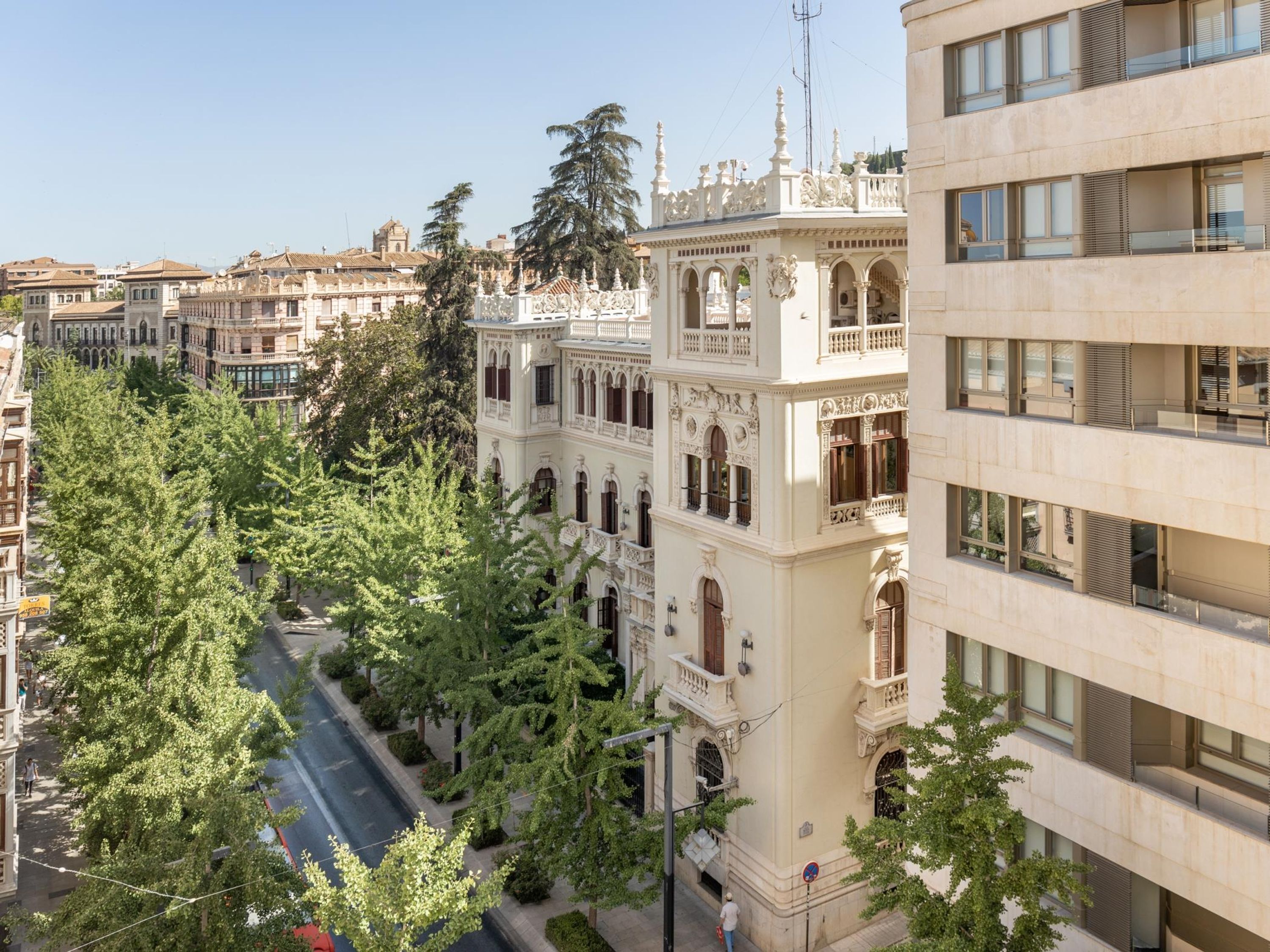 Un edificio de varios pisos con arquitectura clásica, que presenta balcones ornamentados y un patio central.