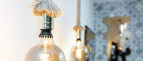 A close-up of a hanging light bulb with a visible filament and a decorative tassel.