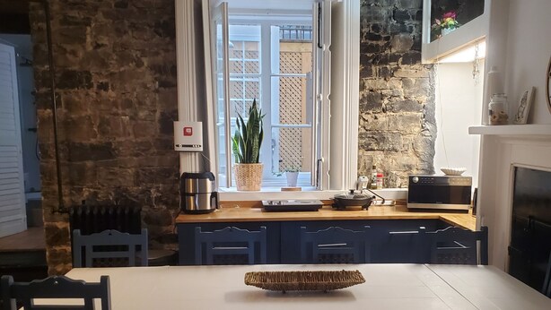 Una cocina moderna con una isla grande, paredes de piedra y vistas al exterior.