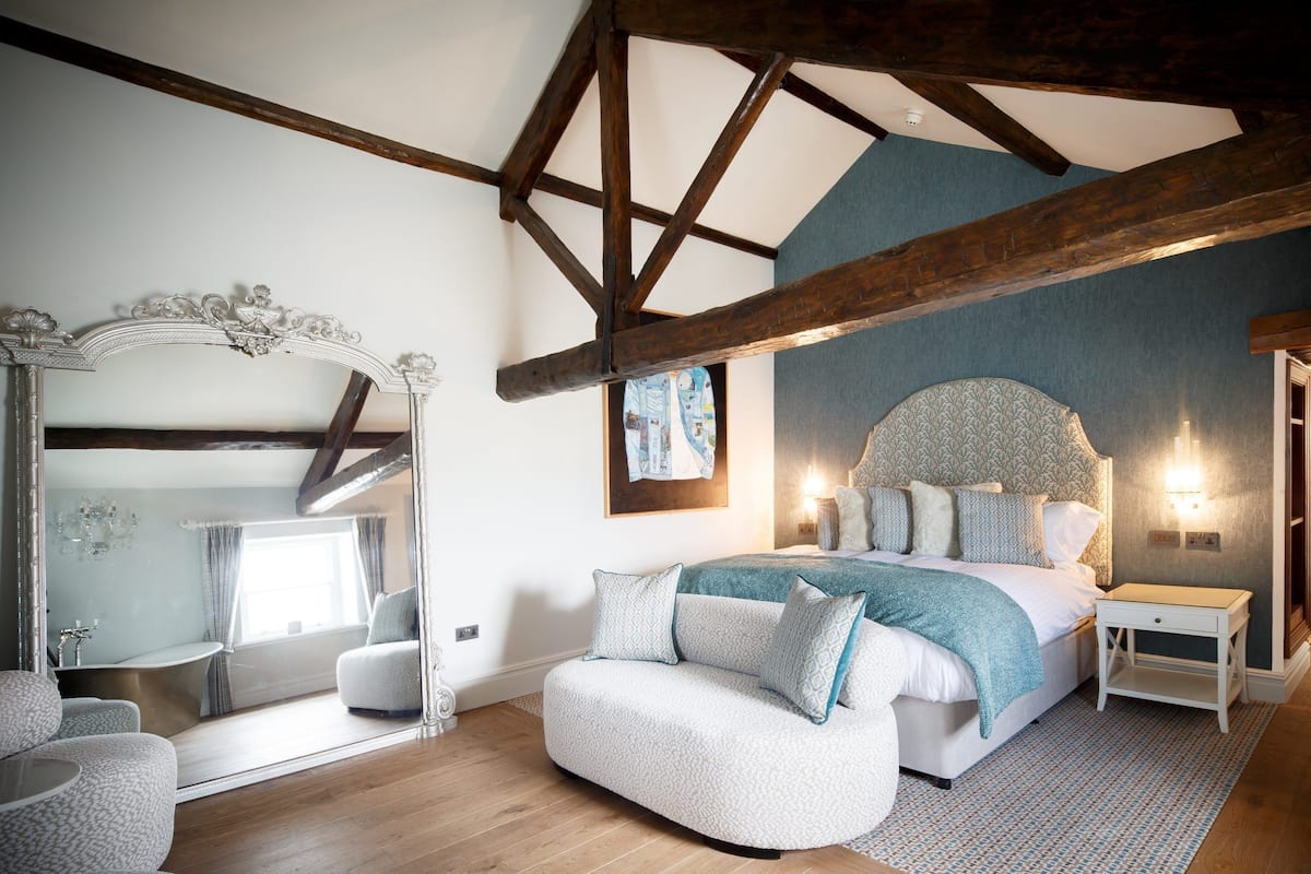 Ein Schlafzimmer mit einem großen Bett, einer Sitzecke, einem Schminktisch und einem Spiegel.