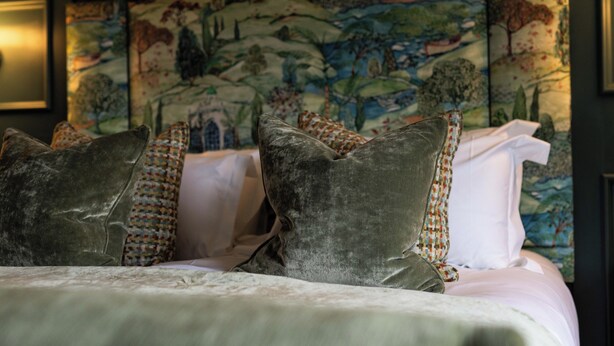A bed with multiple pillows and a decorative headboard. - Aynsome Manor (Grange-over-Sands)