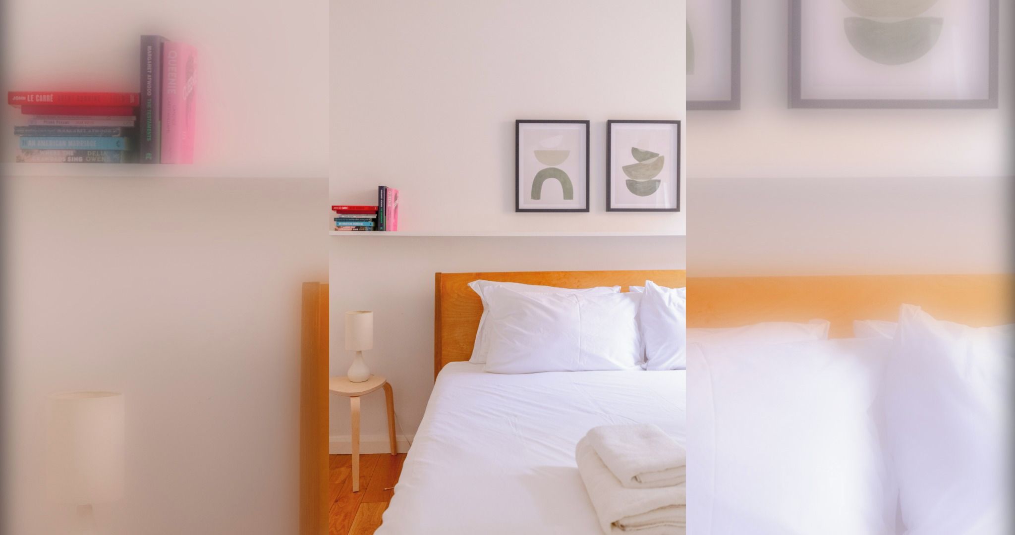 Une chambre d’hôtel avec un lit, une table de chevet, une lampe et une étagère remplie de livres.