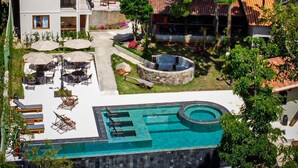 A resort with a swimming pool, outdoor seating, and a garden area. - Pousada Villa Manso (Lima Duarte)