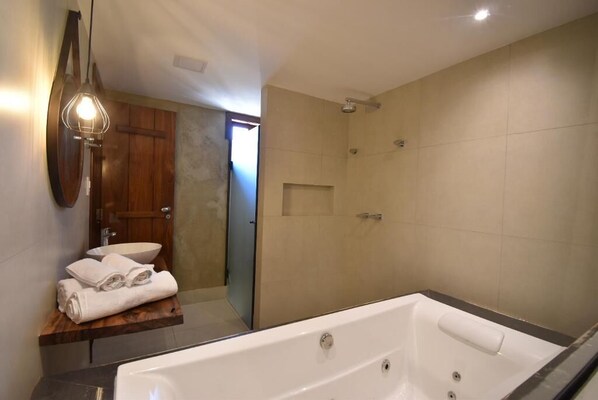 A modern bathroom with a freestanding bathtub, a wooden vanity, a large mirror, and a walk-in shower. - Pousada Villa Manso (Lima Duarte)