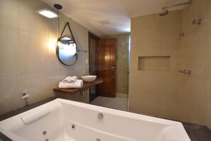 Suite VIP con bañera de hidromasaje, cama king size, vista a la piscina y al jardín | Baño | Toallas, jabón, shampoo, papel de baño