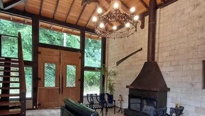 A spacious interior with a wooden ceiling, a fireplace, and a seating area with a sofa and chairs. - Pousada Villa Manso (Lima Duarte)