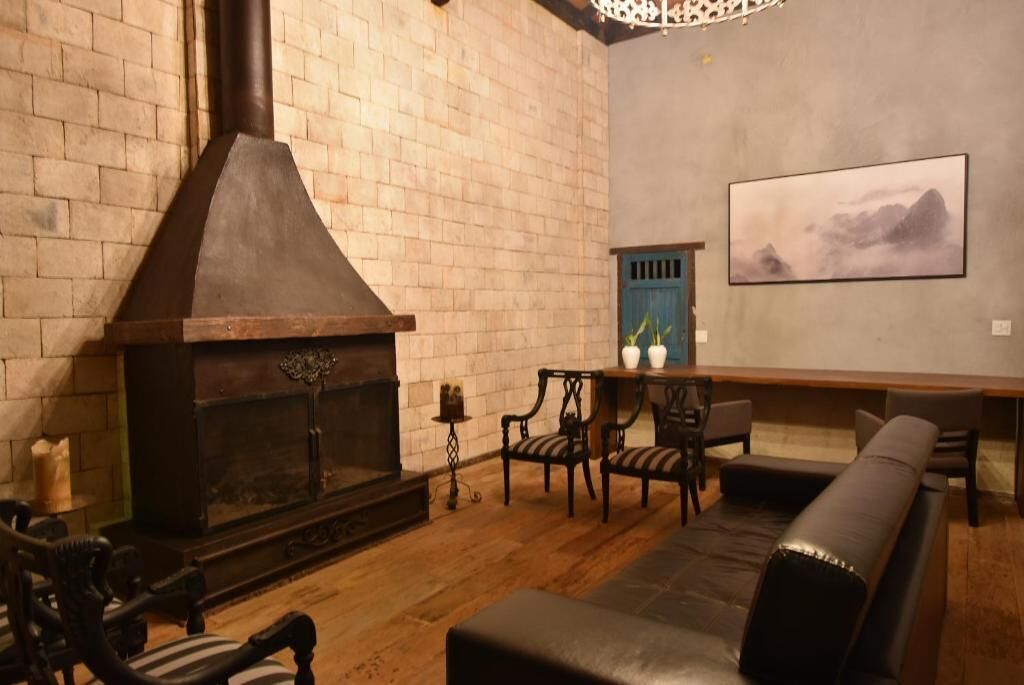 A cozy living room with a fireplace, wooden furniture, and a painting on the wall.