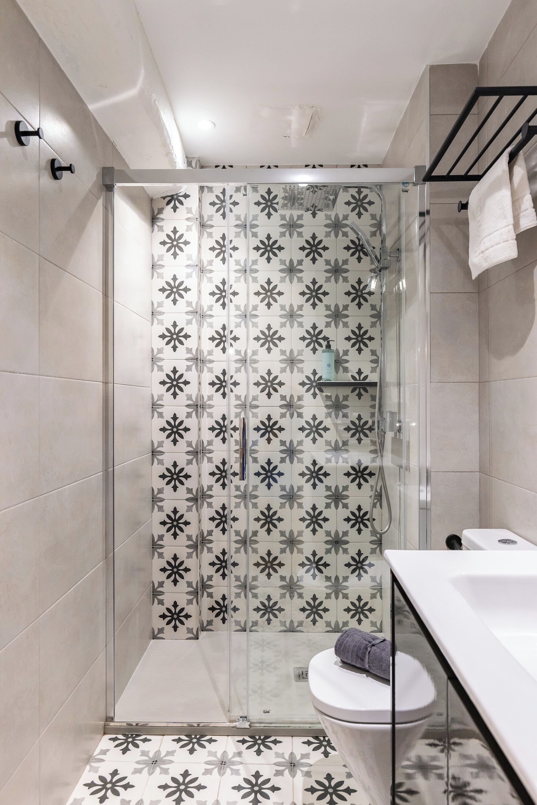 A modern bathroom with a shower enclosure, a toilet, and a sink.