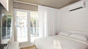 Et hotelværelse med en seng, et vindue med gardiner og en klimaanlæg.