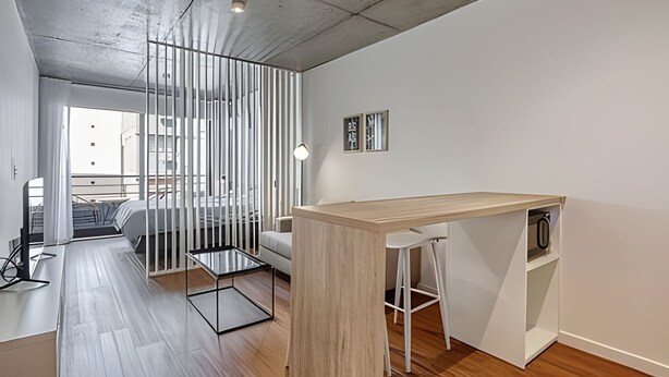 A modern, minimalist bedroom with a bed, a desk, and a chair. - 802 Very bright studio apartment in Belgrano (CABA)