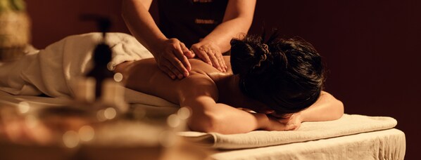 A person receiving a massage on a massage table.