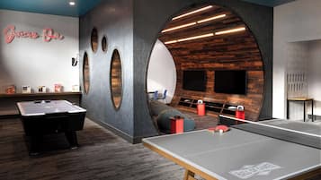 Enjoy a variety of games and entertainment options in this spacious room featuring a foosball table, ping pong table, and pool table.
