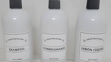 Three bottles of liquid products labeled as shampoo, conditioner, and liquid soap.