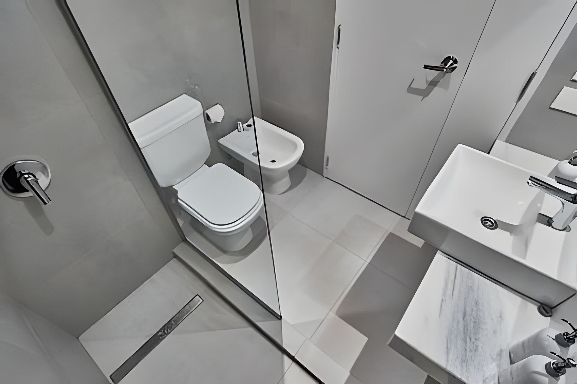 Un baño moderno con inodoro, bidé y lavabo.