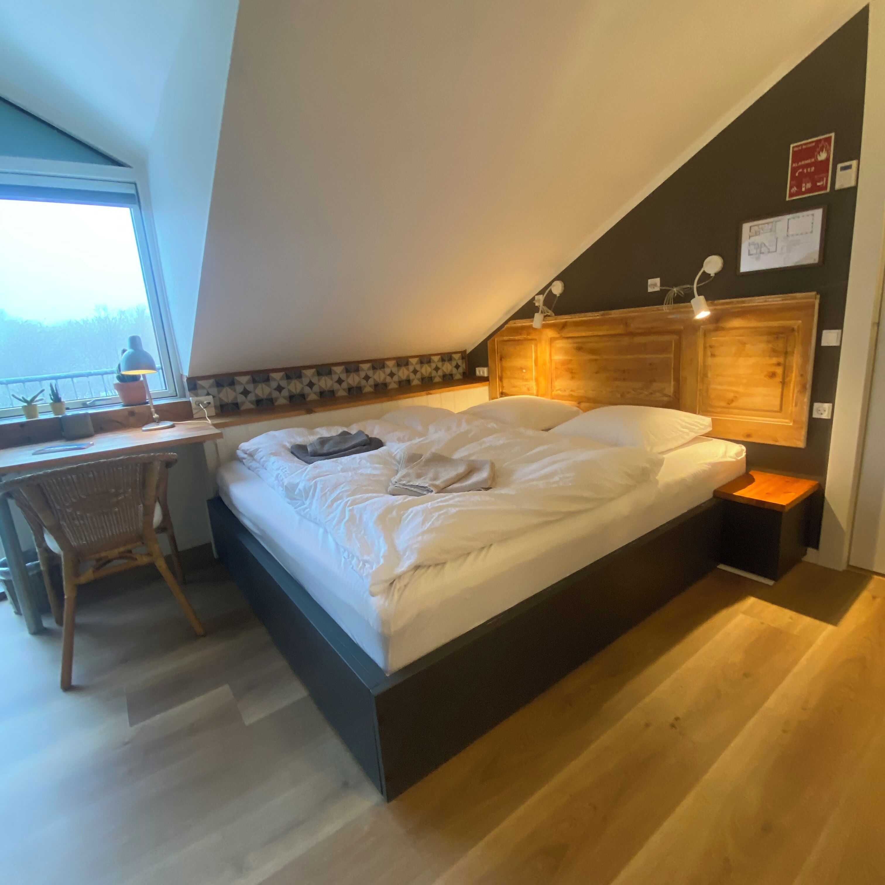 A bedroom with a bed, a desk, and a chair.