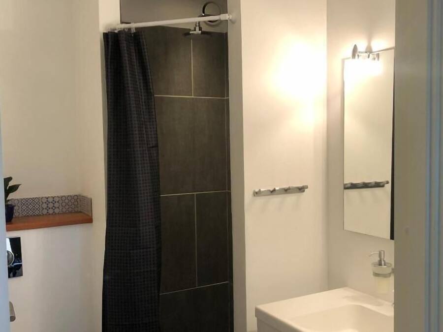 Une salle de bain avec une douche, un lavabo et un miroir.