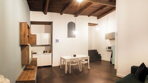Un espace de vie compact comprenant un coin repas, une kitchenette et un coin salon confortable.