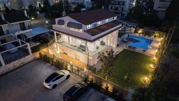 A modern two-story house with a swimming pool, a covered patio, and a car parked in the driveway. - Appartement Sky (Peraia)