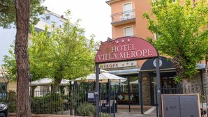A hotel entrance with a sign reading "HOTEL VILLA MEROPE" and a covered outdoor seating area. - Hotel Villa Merope (Rimini)