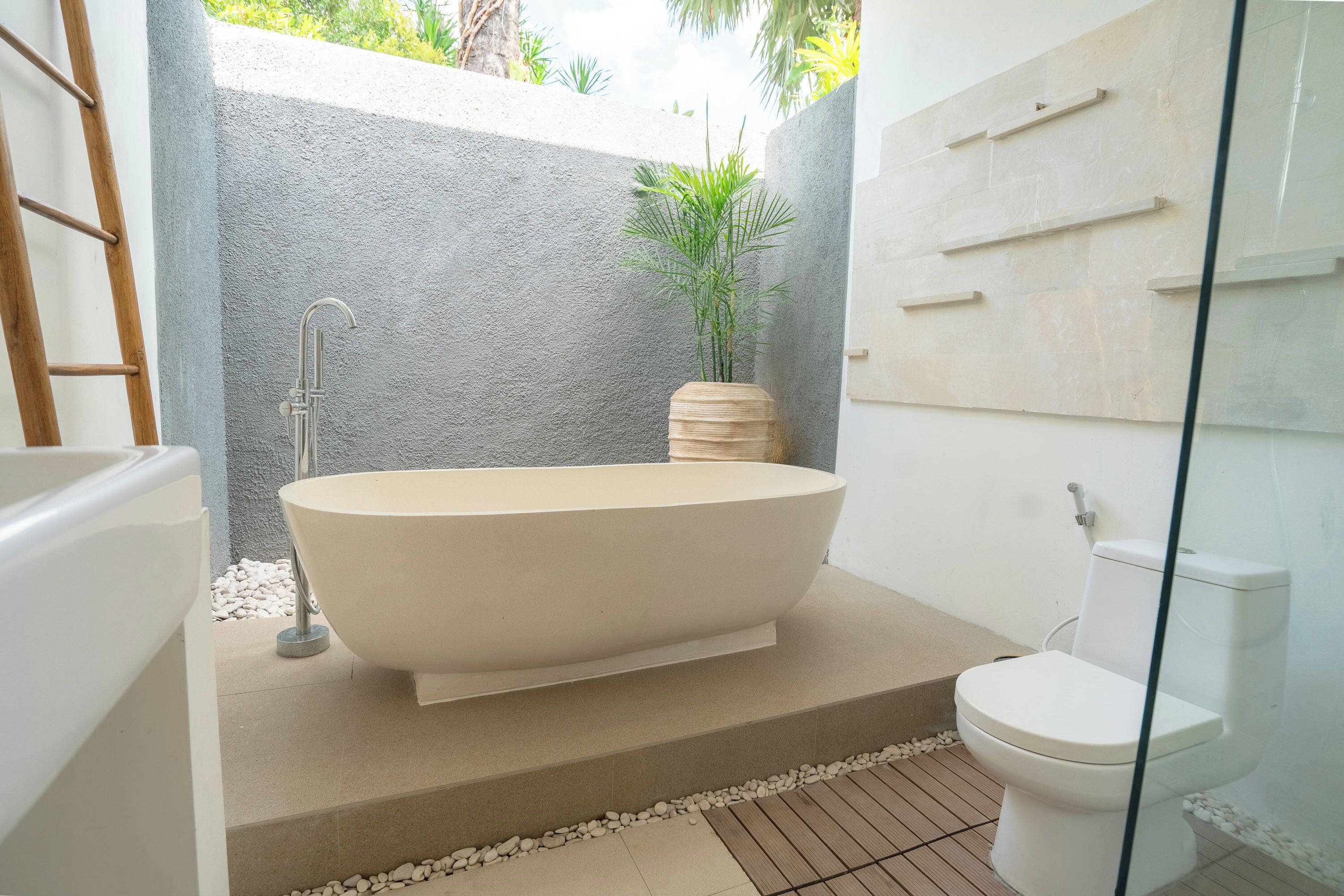 Une salle de bain moderne avec une baignoire sur pieds, des toilettes et une douche à parois de verre.