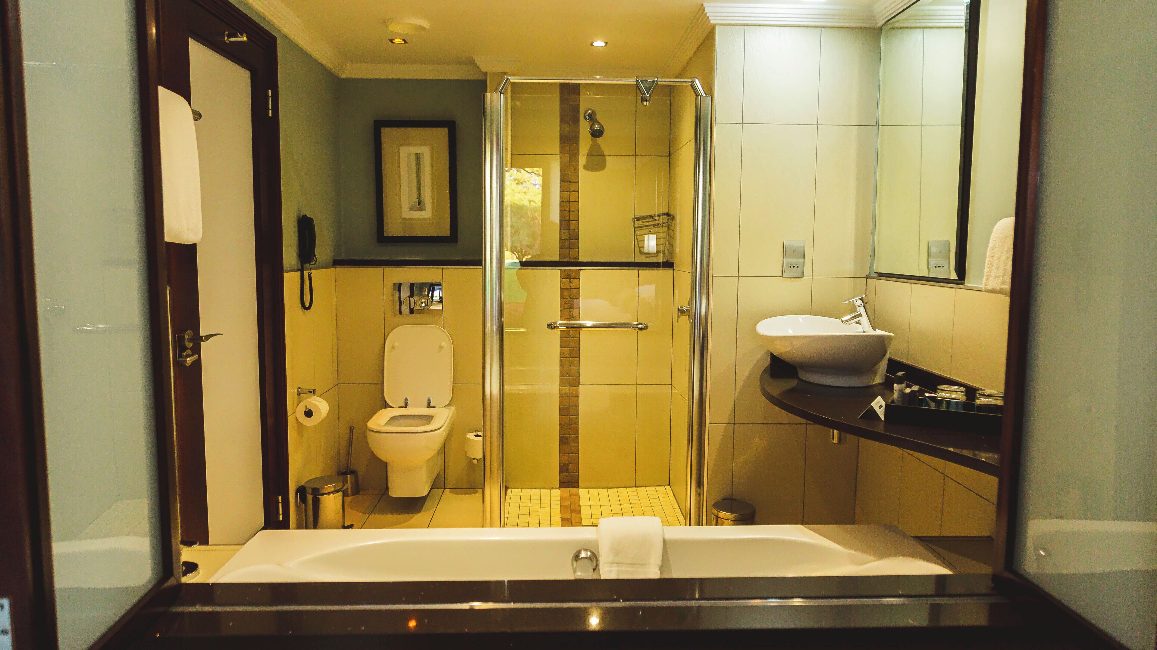 A modern bathroom with a glass-enclosed shower, a toilet, a sink, and a bathtub.