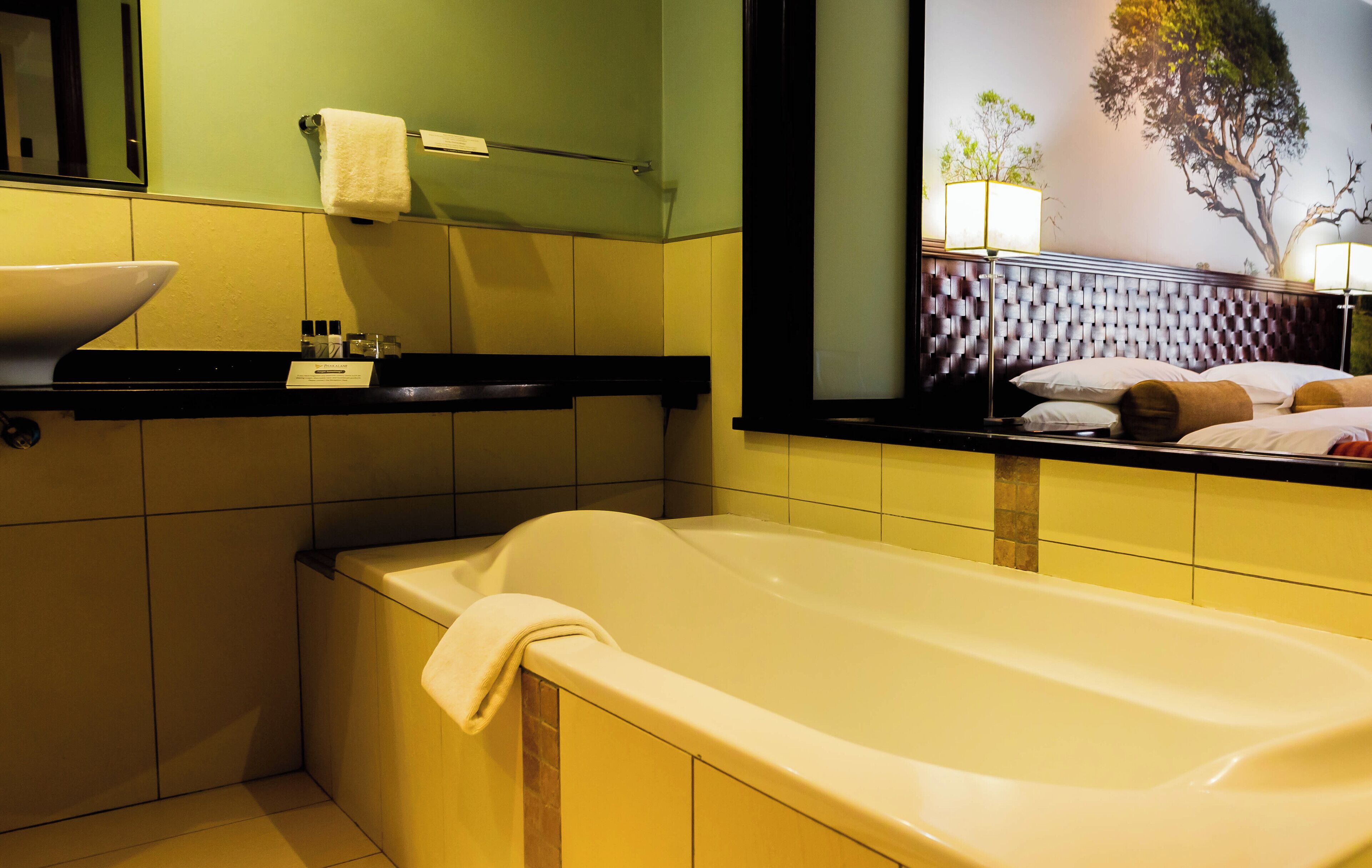 A bathroom with a bathtub, a sink, and a mirror.