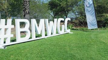 Un letrero blanco grande con el texto '#BMWWGC' sobre un césped.