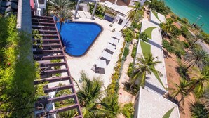 A resort with a swimming pool, palm trees, and a view of the ocean. - Paradise Tamarindo (Sabana de Guacuco)
