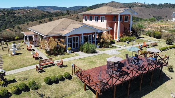 A two-story house with a patio area, a covered deck, and a view of the surrounding hills. - Vila Chantal by Rivaj  (Campos do Jordão)