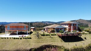 A residential area with two main buildings, one with a balcony and another with a patio. There are several outdoor seating areas and a small pool. - Vila Chantal by Rivaj  (Campos do Jordão)