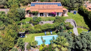 A large house with a swimming pool surrounded by lush greenery and a stone wall. - Villa Bambù 9+2, Emma Villas (Maratea)