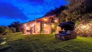 A two-story house with a patio area, a stone wall, and outdoor seating. - Villa Bambù 9+2, Emma Villas (Maratea)