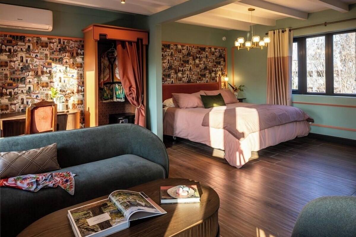 Une chambre à coucher moderne, dotée d’un grand lit, d’un canapé, d’une table basse et d’un mur décoré de photographies.