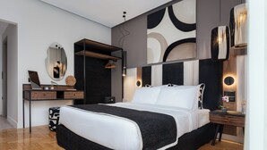 Un dormitorio moderno con una cama grande, un aparador de madera, un espejo y un escritorio con lámpara.