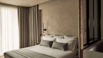 A hotel room with a bed, curtains, a ceiling fan, and a large window.