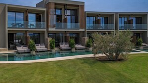 A modern multi-story hotel with a swimming pool, outdoor seating, and a well-maintained lawn. - Zélia Halkidiki, part of Destination by Hyatt - Adults Only (Nea Propontida)