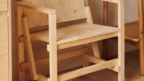 A wooden chair with a slatted backrest and a flat seat, positioned on a wooden floor. - Yarn - Elmo Luxury Double Suite (Ballycastle)
