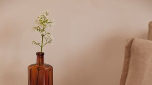 A wooden table with a vase of flowers and a book. - Yarn - Elmo Luxury Double Suite (Ballycastle)