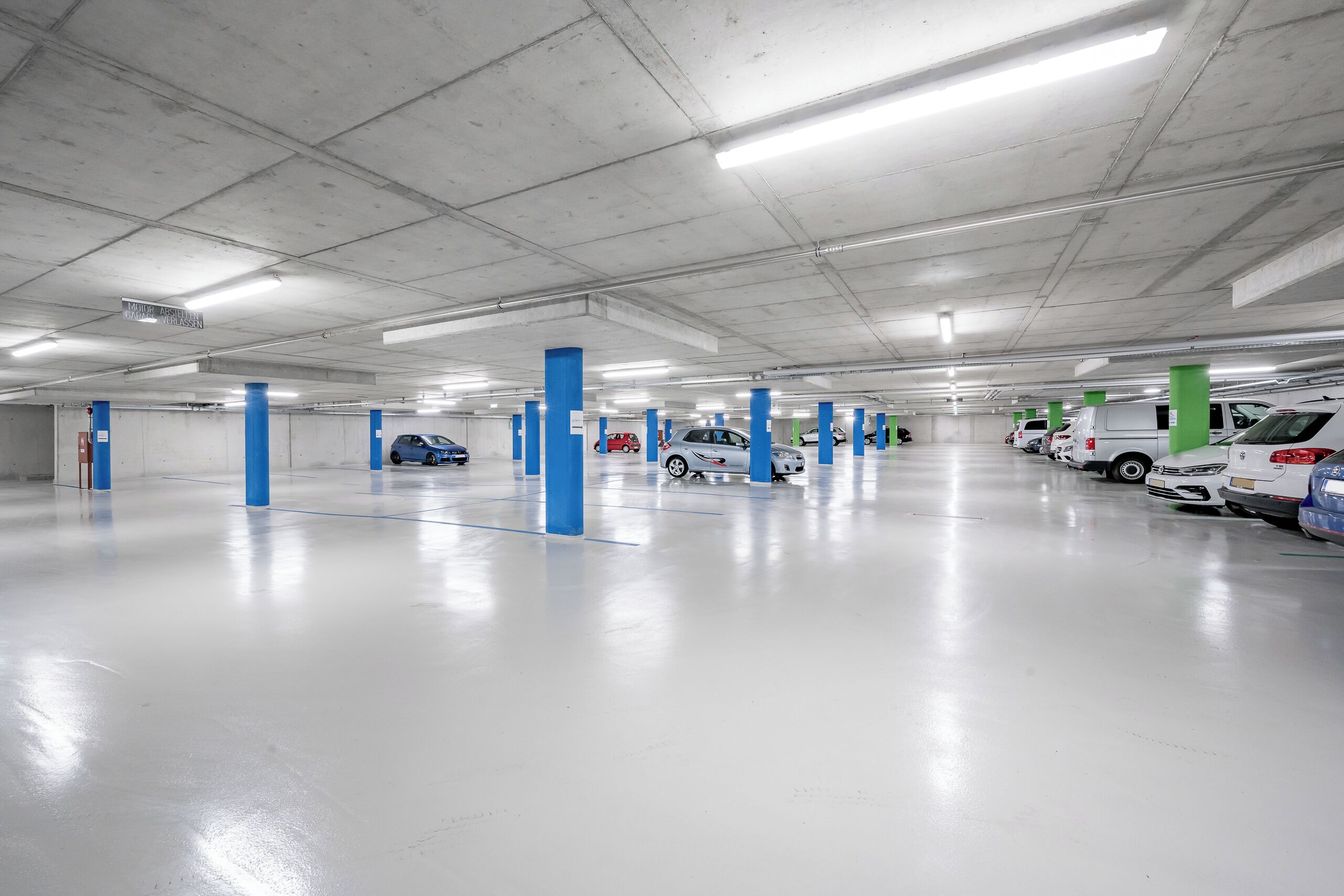 Eine geräumige Parkgarage mit mehreren Ebenen, Betonpfeilern und einer sauberen, gut beleuchteten Umgebung.
