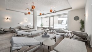 A spa with multiple treatment rooms, each with a massage table and a small round table. - GREEN.Apartments by Camping Sölden (Soelden)