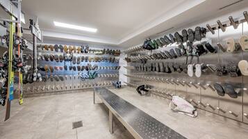 Una zapatería con varios estantes llenos de zapatos y un banco.