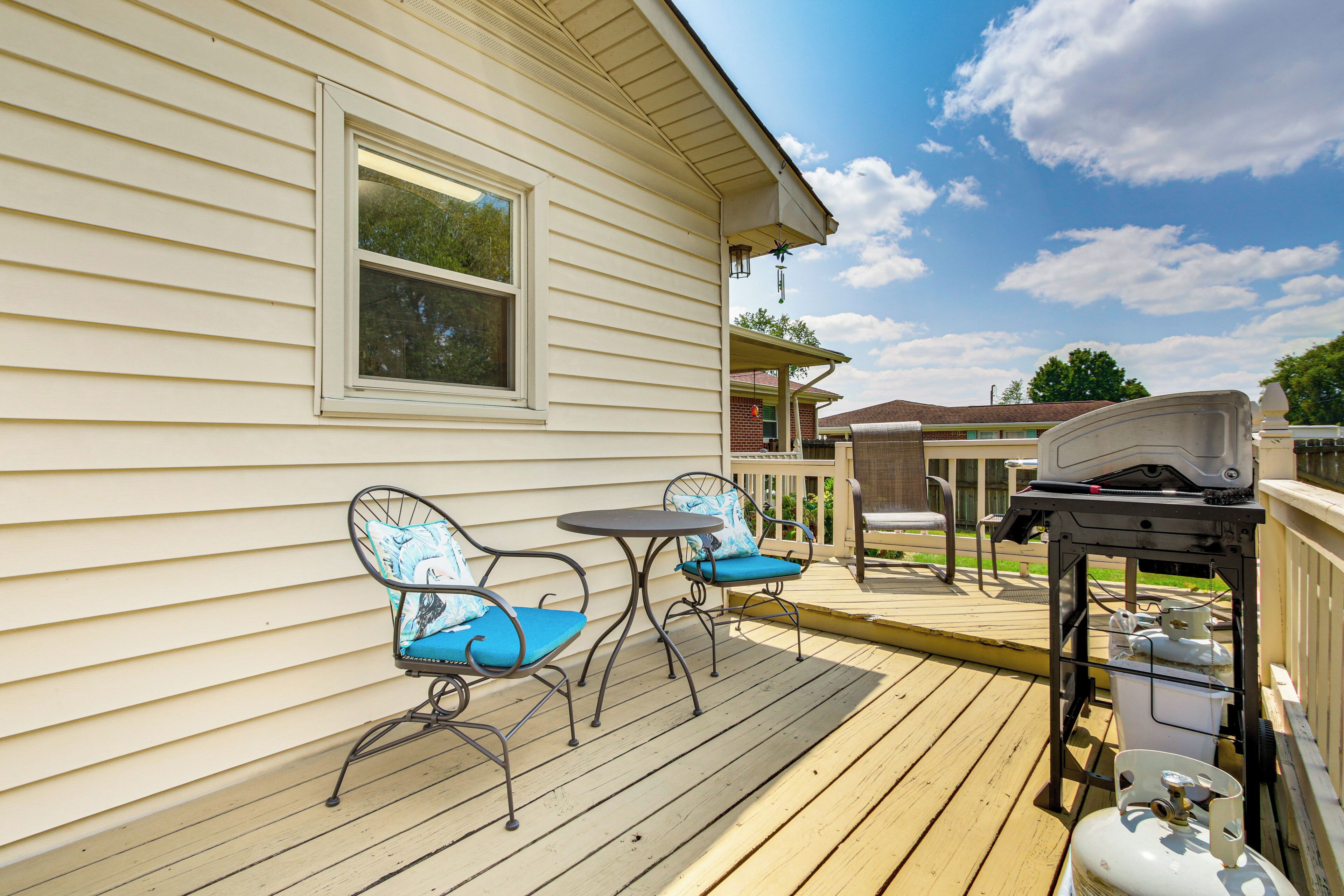 Una terraza de madera con mobiliario exterior y una parrilla de barbacoa.