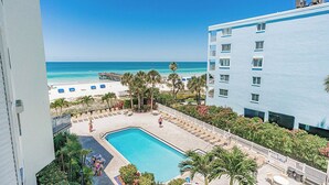 Ein Hotel mit Pool, Meerblick und einer Sitzgelegenheit im Freien.