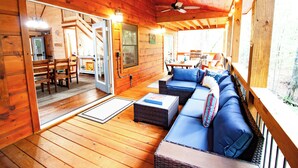 A wooden cabin interior with a sofa, dining table, and ceiling fan. - Fall Sale! Luxury Cabin. Top Location. Hot Tub Game Room EV Firepit (Blue Ridge)