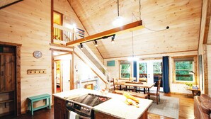 A spacious wooden cabin with a kitchen, dining area, and a staircase leading to a loft. - Fall Sale! Luxury Cabin. Top Location. Hot Tub Game Room EV Firepit (Blue Ridge)