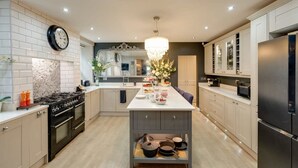 Une cuisine moderne dotée d’un îlot central, d’une cuisinière, de placards et d’un réfrigérateur.