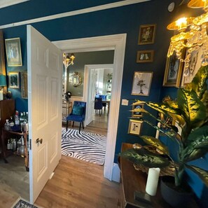 A hallway with a zebra-patterned rug, a blue chair, and a plant in a vase. - Luxury Georgian Country House With Hot Tub (Ross-on-Wye)